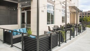 A building with a number 305 sign, outdoor seating with cushions, and string lights. - Fairfield by Marriott Inn & Suites Dayton Downtown (Dayton)