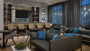 A modern hotel lobby with a bar area, seating arrangements, and a large window with curtains. - Fairfield by Marriott Inn & Suites Dayton Downtown (Dayton)