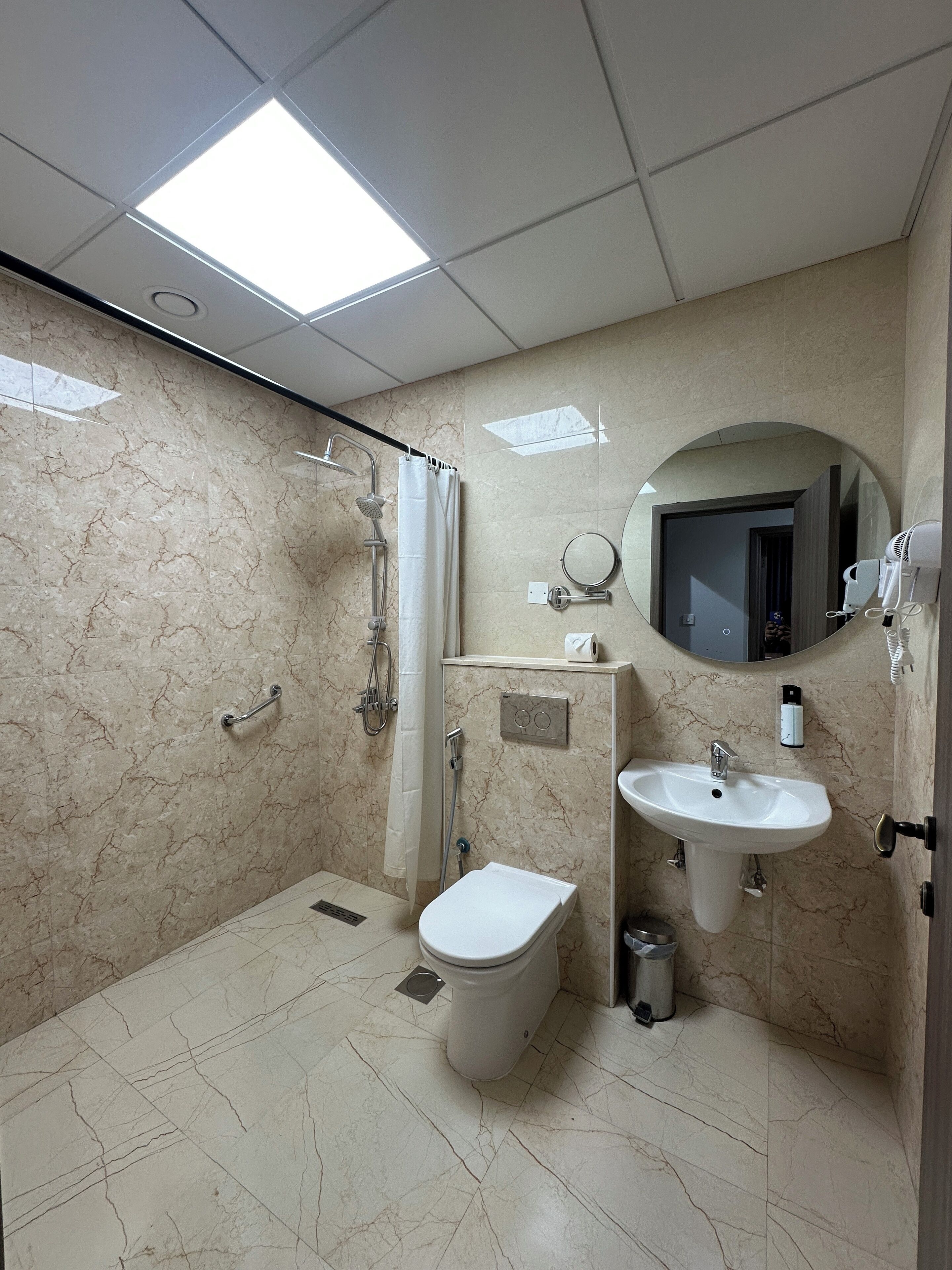 Ein modernes Badezimmer mit Dusche, Toilette, Waschbecken und Spiegel.
