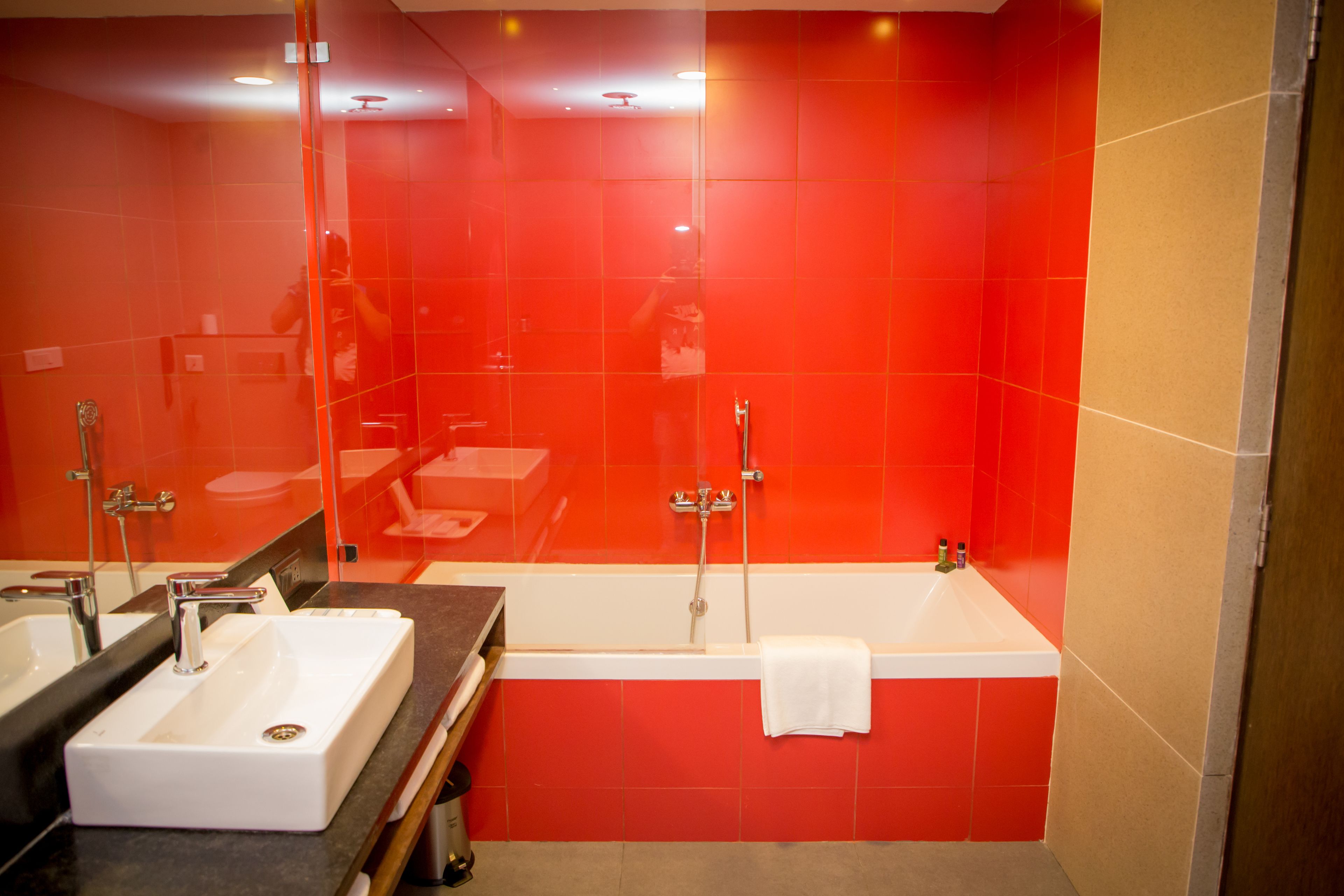 Een moderne badkamer met twee wasbakken, een bad en een grote spiegel.
