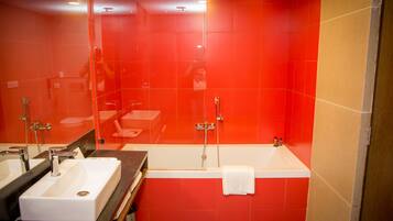 Een moderne badkamer met twee wasbakken, een bad en een grote spiegel.