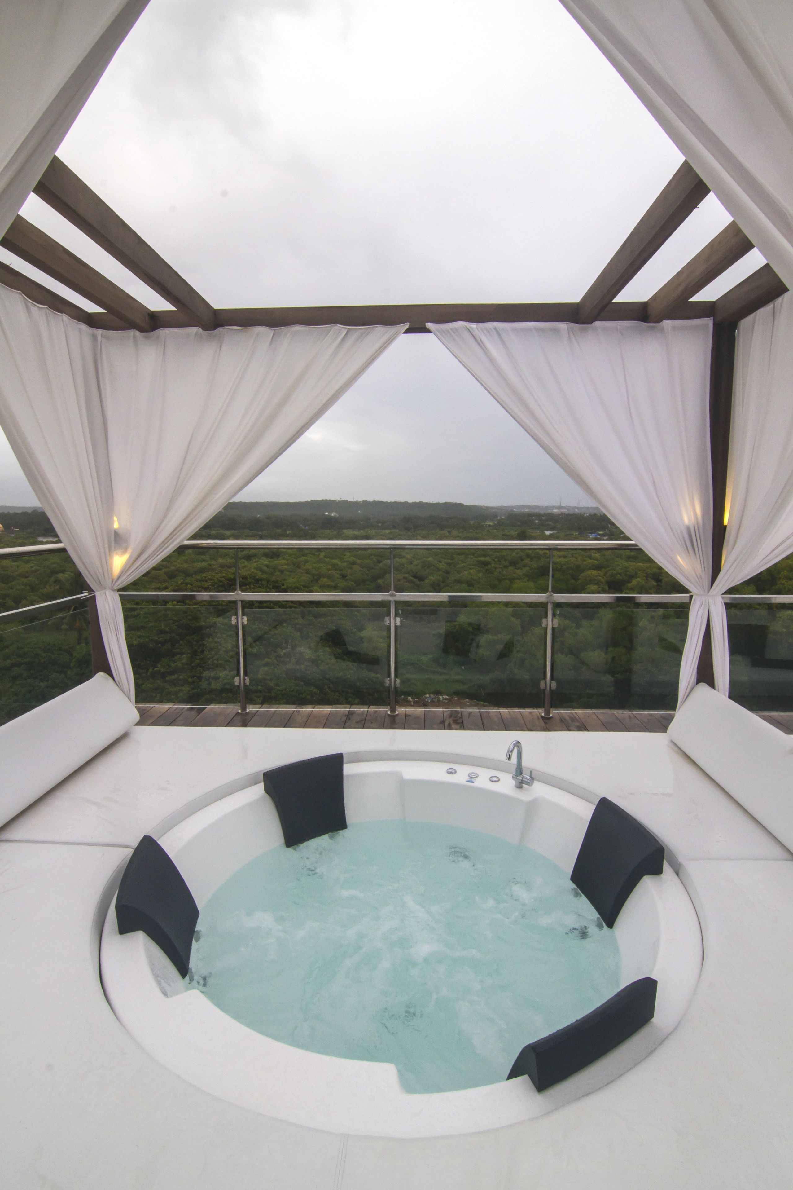 A hot tub with a panoramic view of a lush landscape.