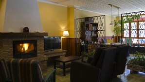 A living room with a fireplace, a television, and a seating area.