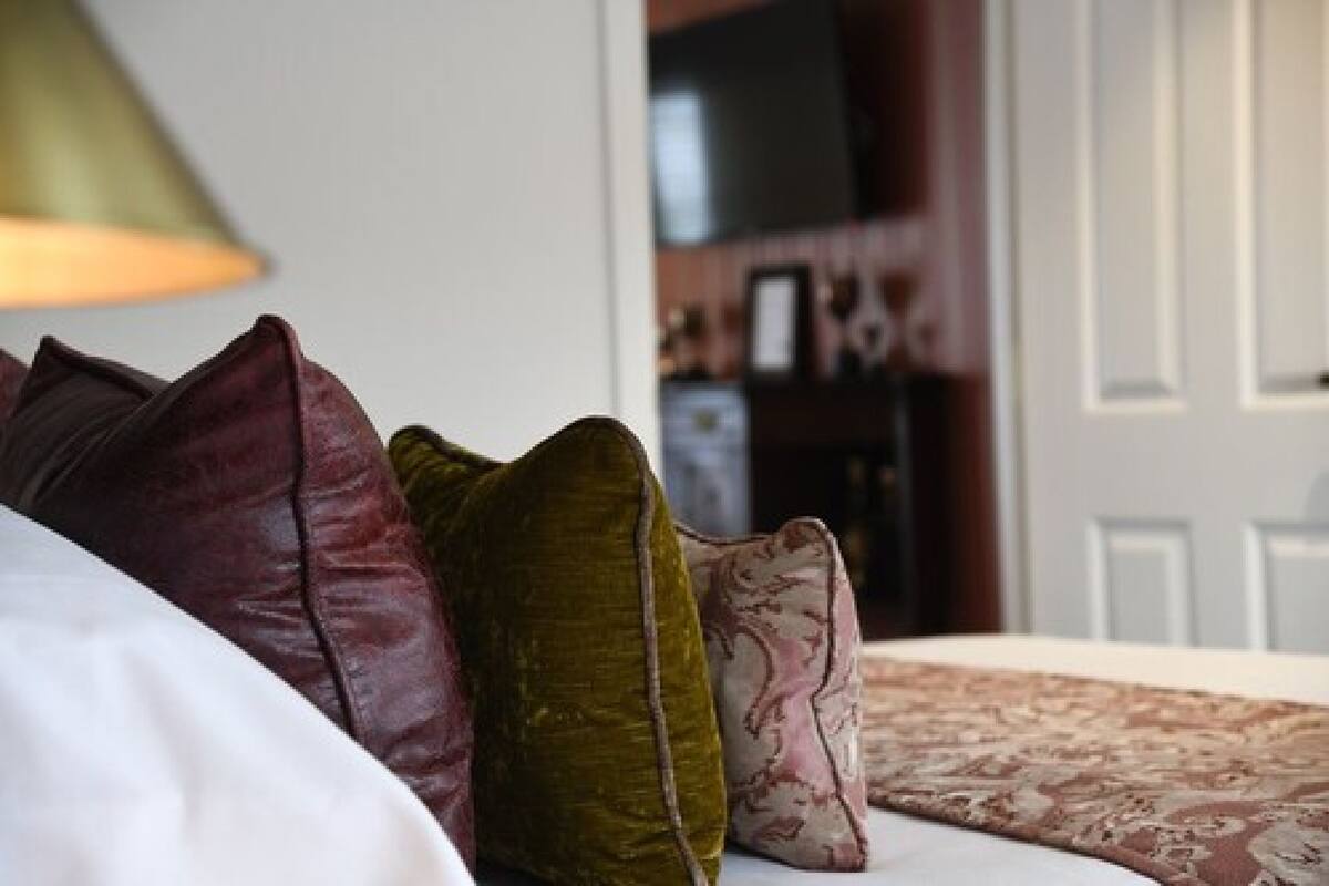 A bed with multiple pillows and a patterned bedspread.