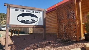 A wooden building with a sign reading "East Zion - Glendale Ranch Cabins".