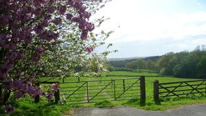 A rural landscape with a gated entrance, green fields, and trees. - Moaps Farm Bed and Breakfast (Haywards Heath)