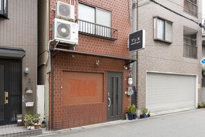 A multi-story building with a brick facade, a closed garage door, and a sign that reads "sound & space".