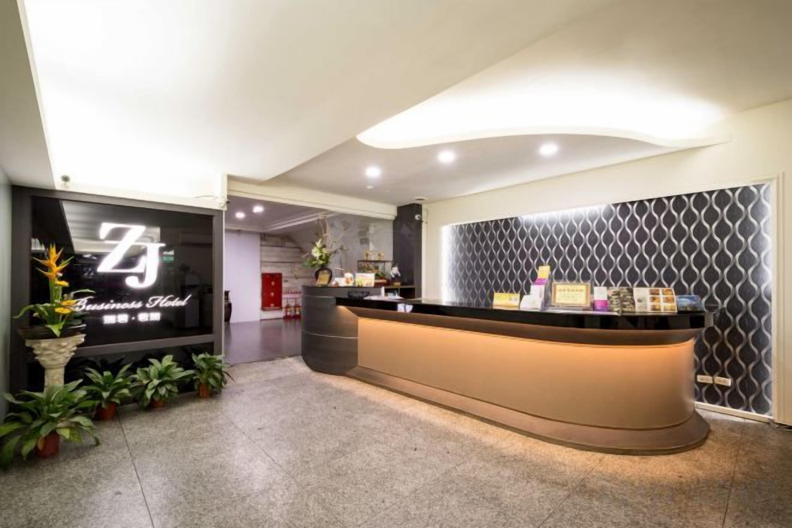A reception area with a curved counter, a reception desk, and a wall with a geometric pattern.