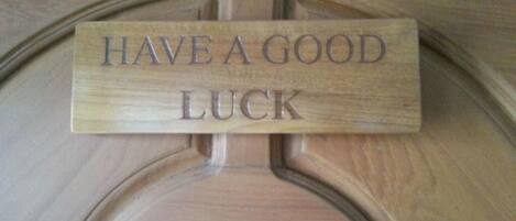 A wooden plaque with the text "HAVE A GOOD LUCK" on a door.