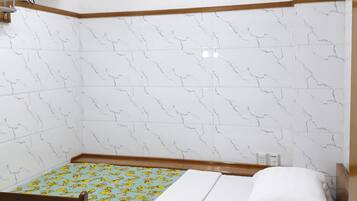 Una habitación pequeña y ordenada, con una cama, un escritorio y una silla.