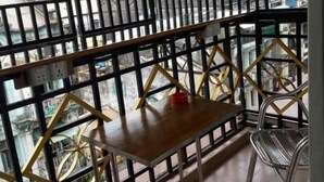 A balcony with a metal railing, a wooden table, and a chair. - Chan Myae Guest House (Yangon)