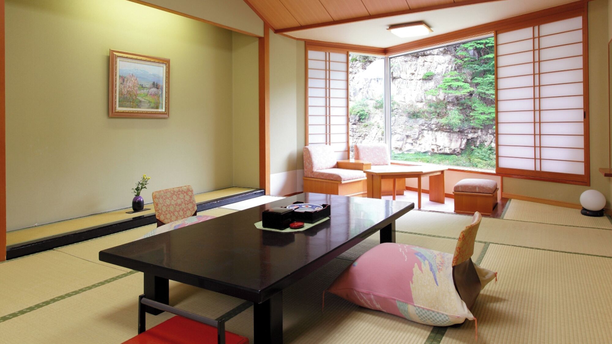 Ein traditioneller japanischer Raum mit Tatami-Böden, einem niedrigen Tisch und Schiebetüren.