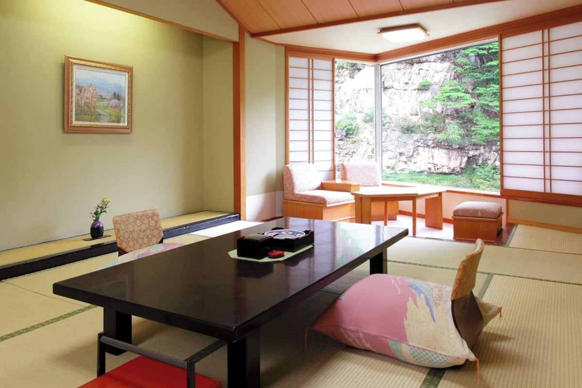 A traditional Japanese room with tatami flooring, a low table, and sliding doors.