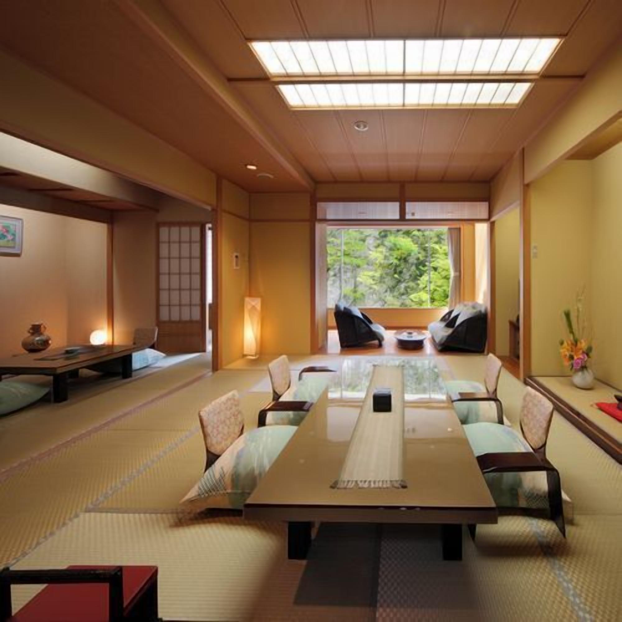 Ein traditioneller japanischer Raum mit Tatami-Boden, einem niedrigen Tisch und Sitzgelegenheiten.