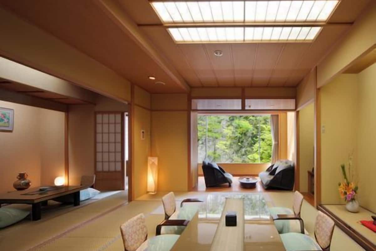 A traditional Japanese-style room with tatami flooring, a low table, and seating.