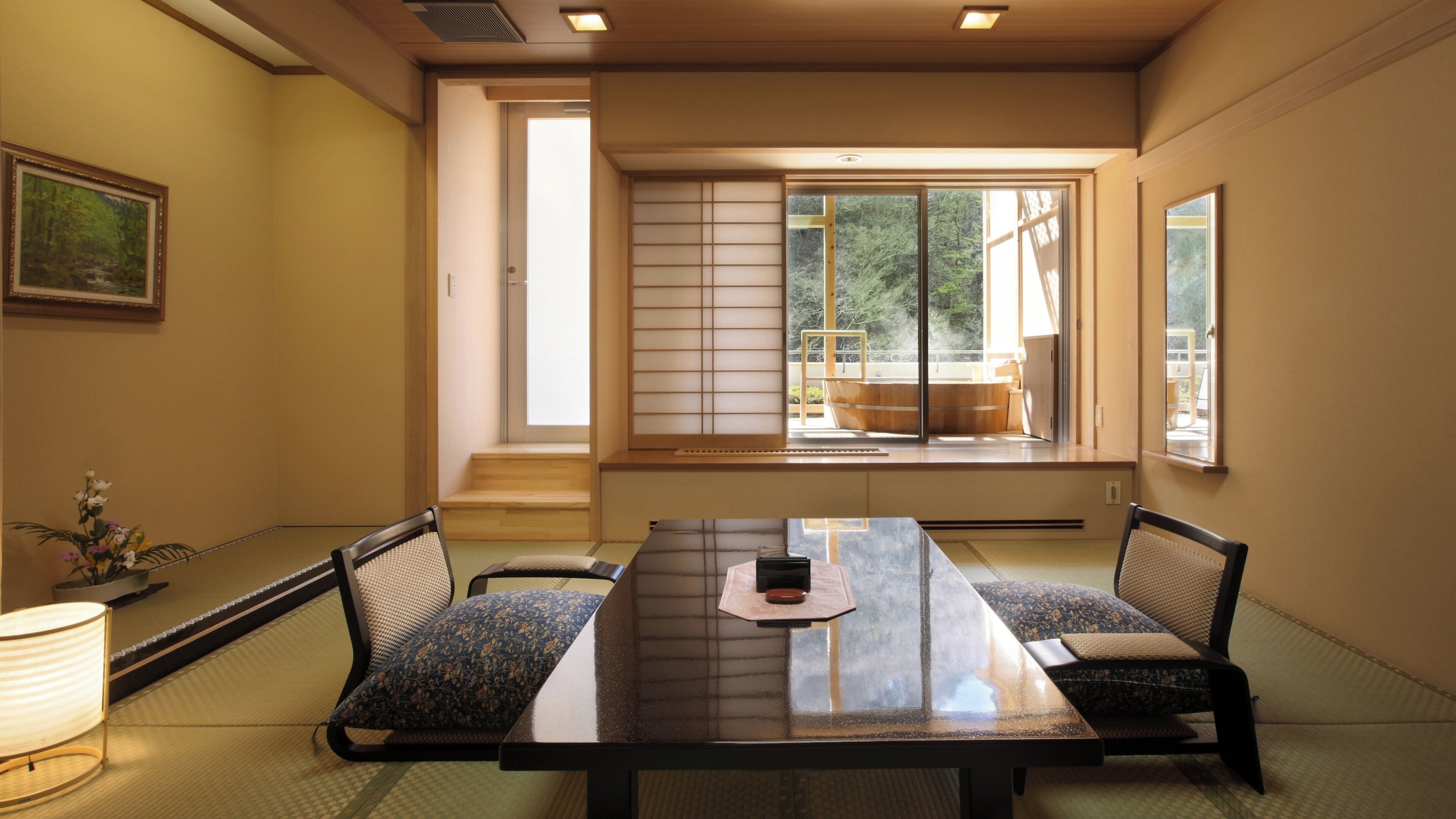 Ein traditioneller japanischer Raum mit Tatami-Bodenbelag, einem niedrigen Tisch und Shoji-Schirmwänden.