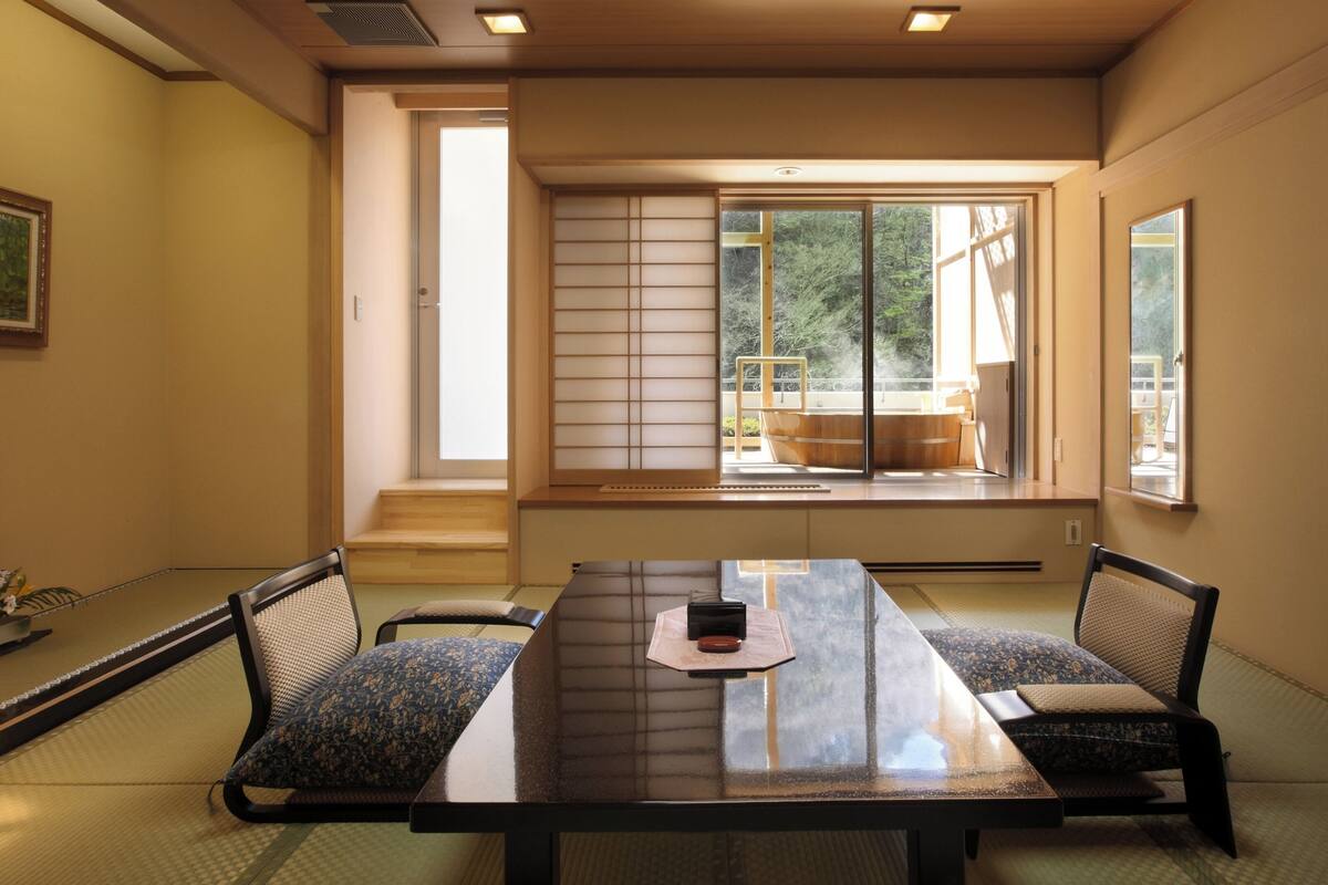 A traditional Japanese room with tatami flooring, a low table, and shoji screens.