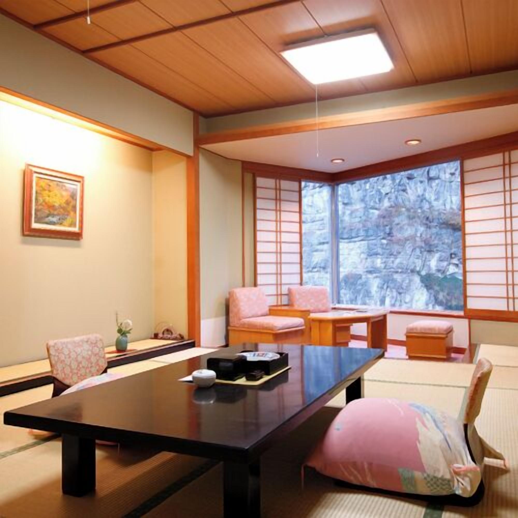 Ein traditioneller japanischer Raum mit Tatami-Boden, einem niedrigen Tisch und verschiebbaren Shoji-Türen.