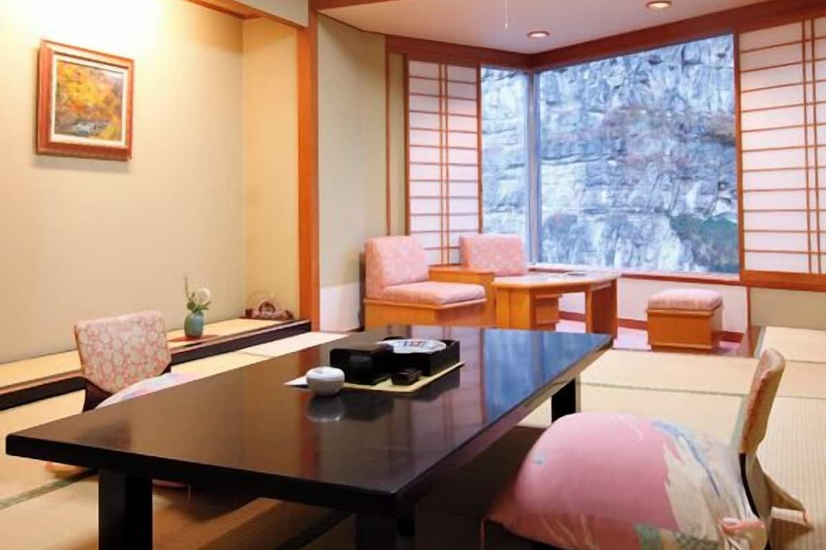 A traditional Japanese room with tatami flooring, a low table, and sliding shoji doors.