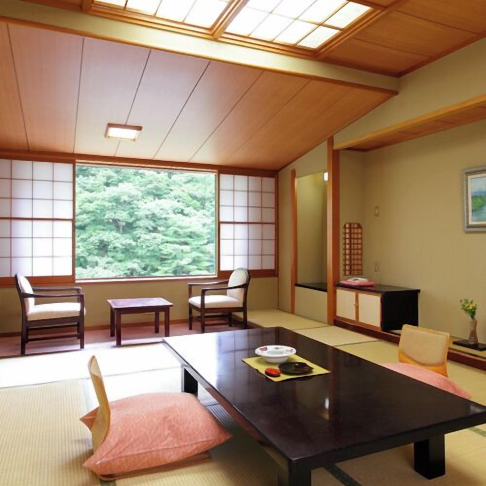 Ein traditioneller japanischer Raum mit Tatami-Böden, einem niedrigen Tisch und Shoji-Schirmwänden.