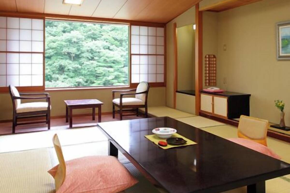 A traditional Japanese room with tatami flooring, a low table, and shoji screens.
