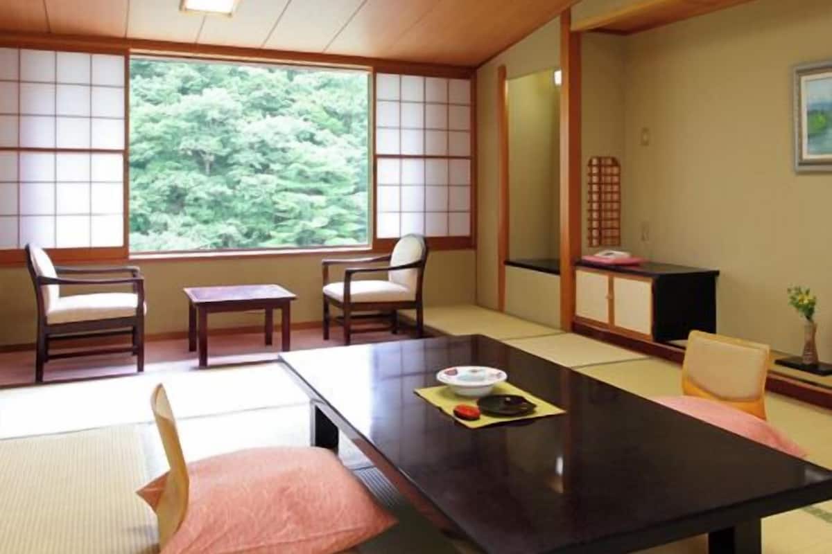 Ein traditioneller japanischer Raum mit Tatami-Böden, einem niedrigen Tisch und Shoji-Schirmwänden.