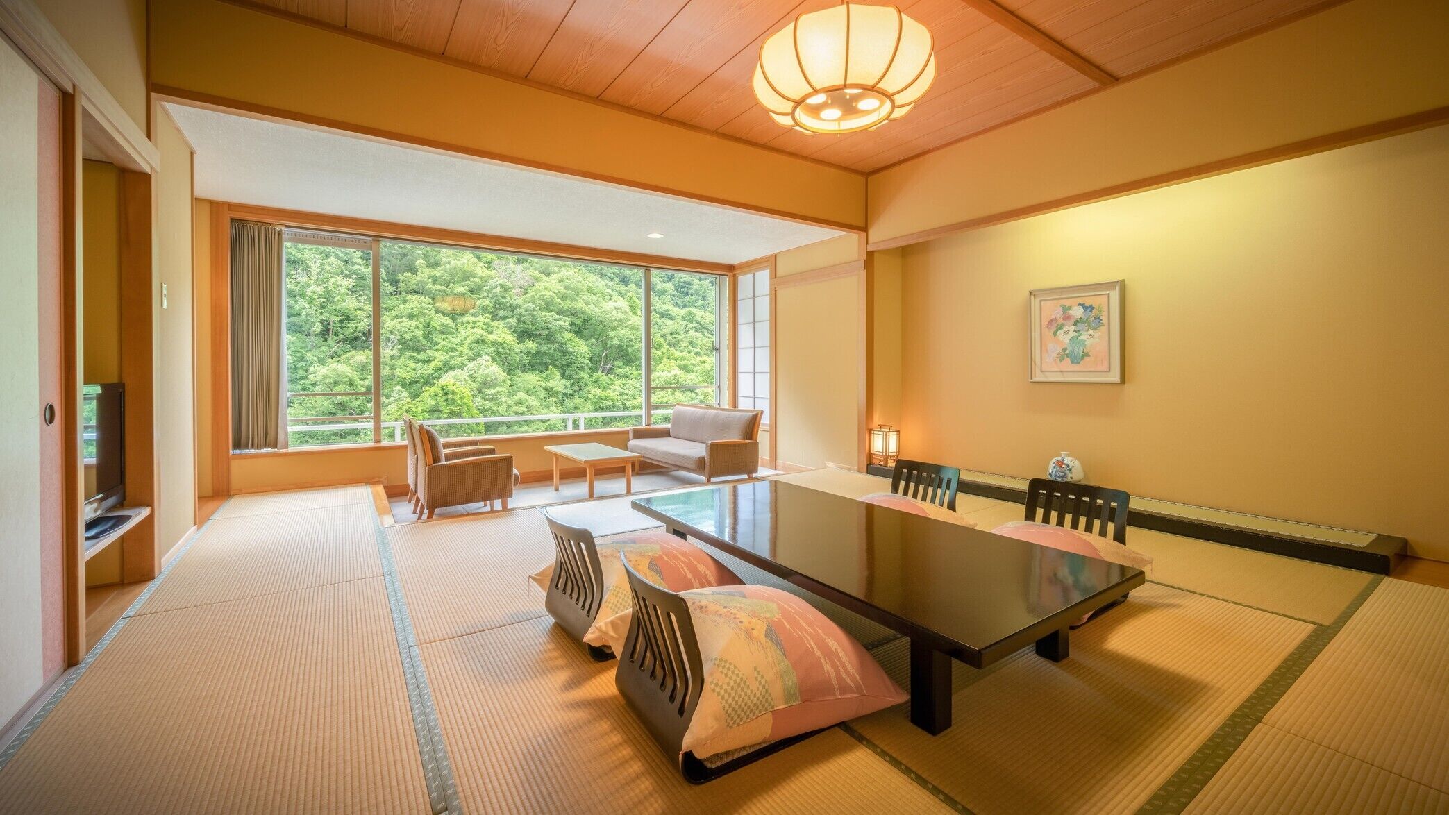 A traditional Japanese room with tatami flooring, a low table, and a sofa.