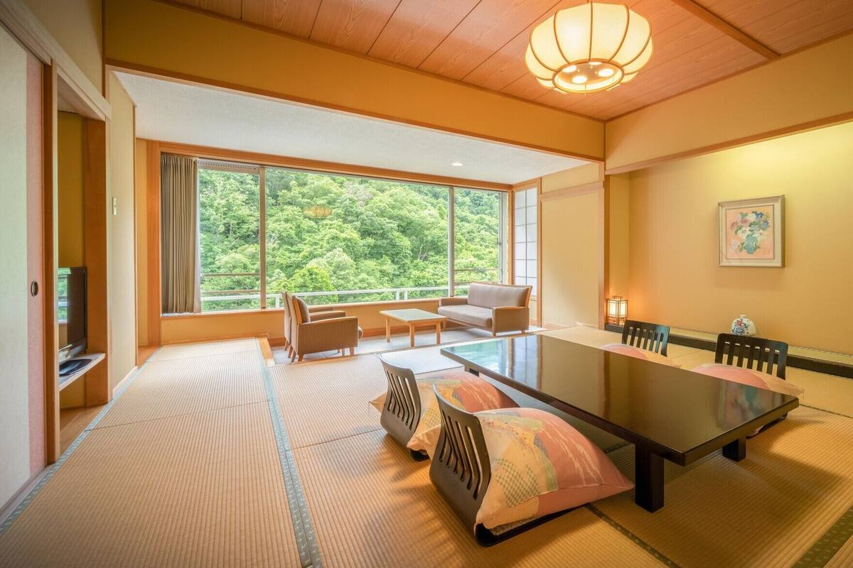 A traditional Japanese room with tatami flooring, a low table, and a sofa.