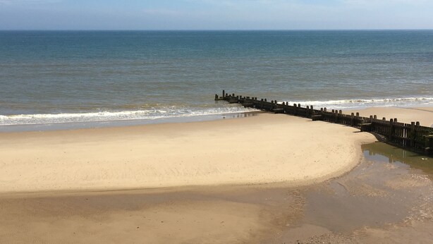 A beach with a wooden jetty extending into the ocean. - The Leas Beach Park (Norwich)