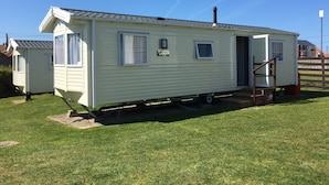 A mobile home with a small porch and a single window. - The Leas Beach Park (Norwich)