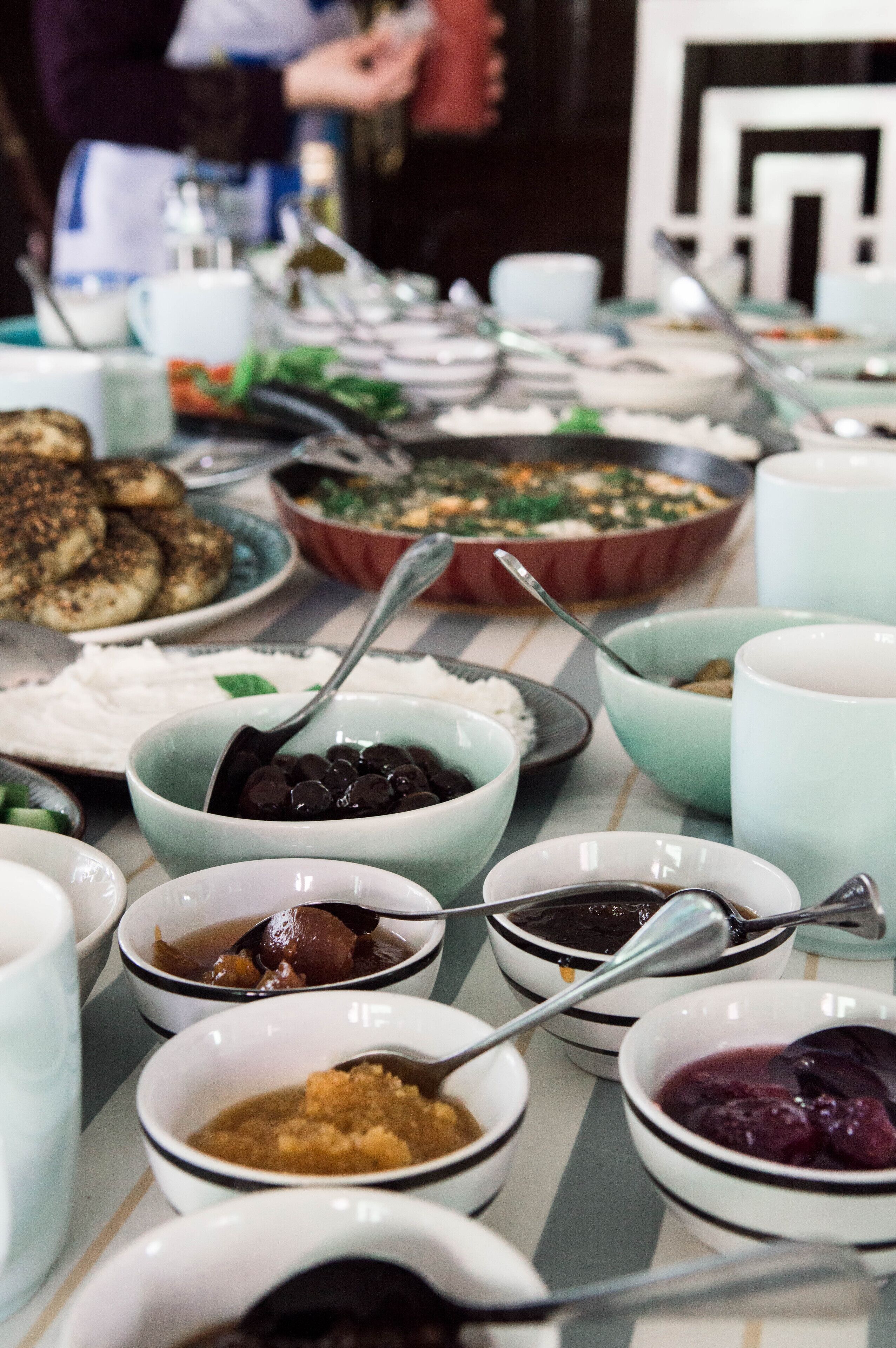 A buffet table with various dishes and bowls.