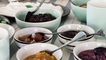 A buffet table with various dishes and bowls.