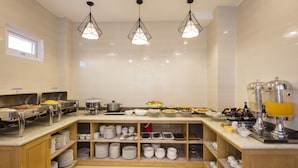 A buffet setup with multiple food stations, a coffee machine, and a variety of dishes. - Hanka Star Hotel (Nha Trang)