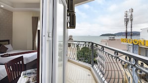 A balcony with a view of the sea, a bed, and a chair. - Hanka Star Hotel (Nha Trang)