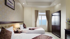 A hotel room with two beds, a large wardrobe, a television, and a window with curtains. - Hanka Star Hotel (Nha Trang)
