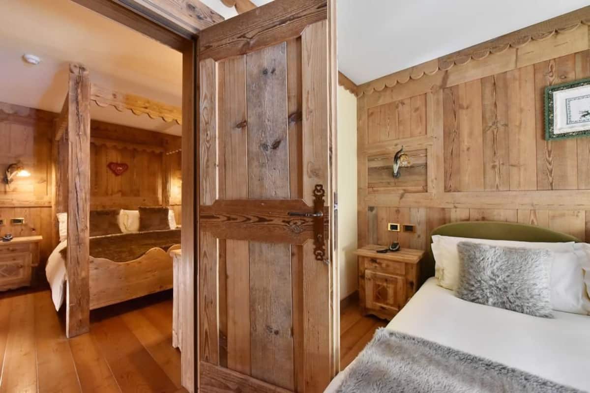 A wooden room with a bed, a nightstand, and a dresser.