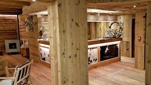 Un interior de madera con una recepción, una chimenea y una silla de madera.