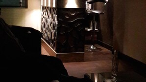 A dimly lit bar area with a modern design, including a bar counter and seating. - Hotel Sheela (Agra)