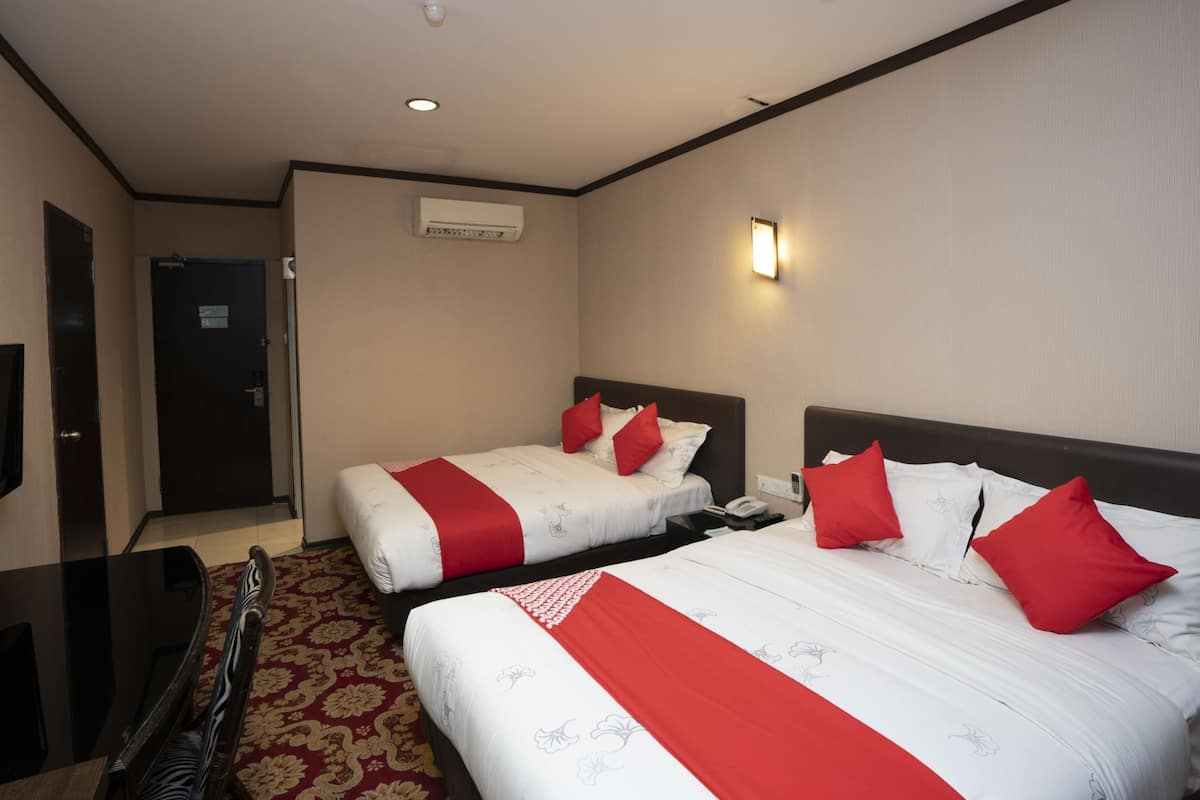 A hotel room with two beds, a desk, and a chair.
