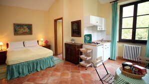 A bedroom with a bed, bedside table, lamp, and a painting on the wall. - Tenuta Guazzaura (Serralunga di Crea)