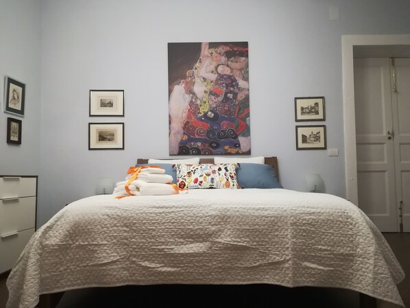 A bedroom with a bed, pillows, a blanket, and a wall painting. - La magnolia B&B (Baronissi)