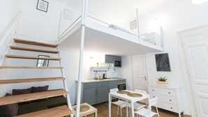Eine kompakte, moderne Wohnung mit Schlafgalerie, Küchenzeile und Essbereich.