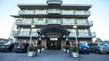 Hotel entrance with a canopy and parking available.