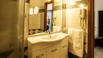 A bathroom with a sink, mirror, towel rack, and a telephone.