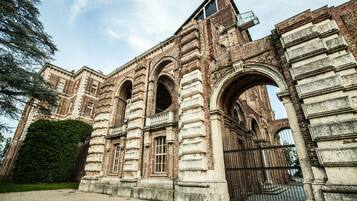 Un edificio histórico con ventanas de arco y una entrada portonada.