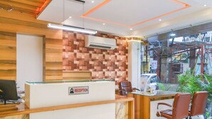 Un comptoir d’accueil avec une pancarte indiquant « RÉCEPTION », un mur en bois et une vue sur la rue.