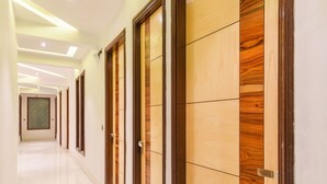 Un couloir avec des portes en bois et un plancher ciré.