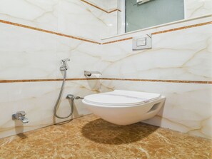 A bathroom with a toilet, a shower, and a mirror. - Capital O 16131 Mohit Guest House (New Delhi)