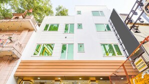 Un bâtiment moderne doté de nombreuses fenêtres et d’une porte d’entrée en bois.