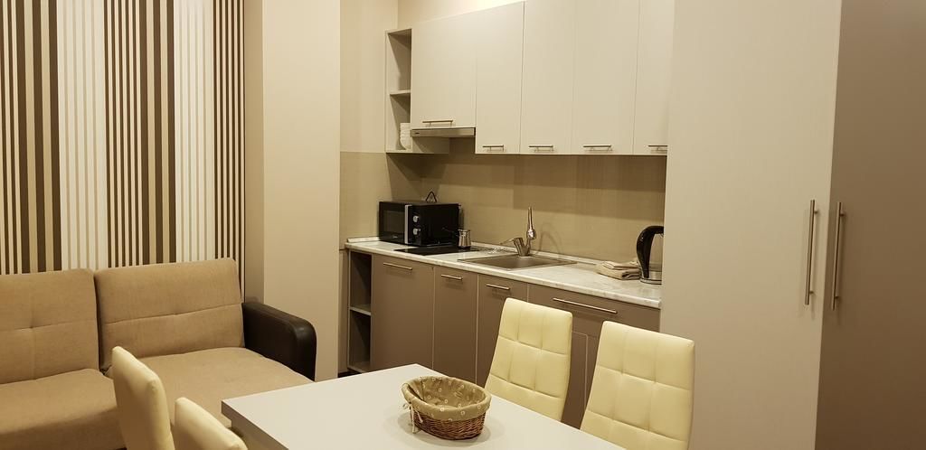 A compact living space with a kitchenette, a dining area, and a sofa.